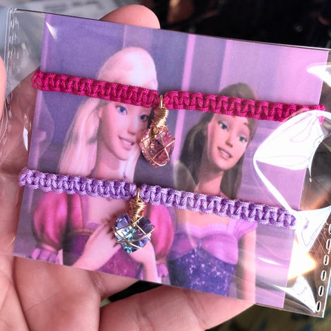 Dúo pulseras corazón rosa y morado.