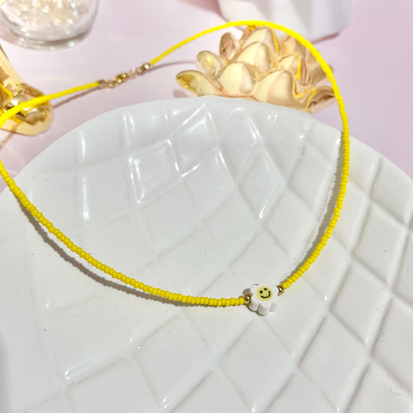 Collar amarillo con margarita.